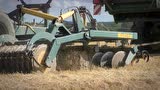 约翰迪尔T670i一边收割一边牵引农具耙地